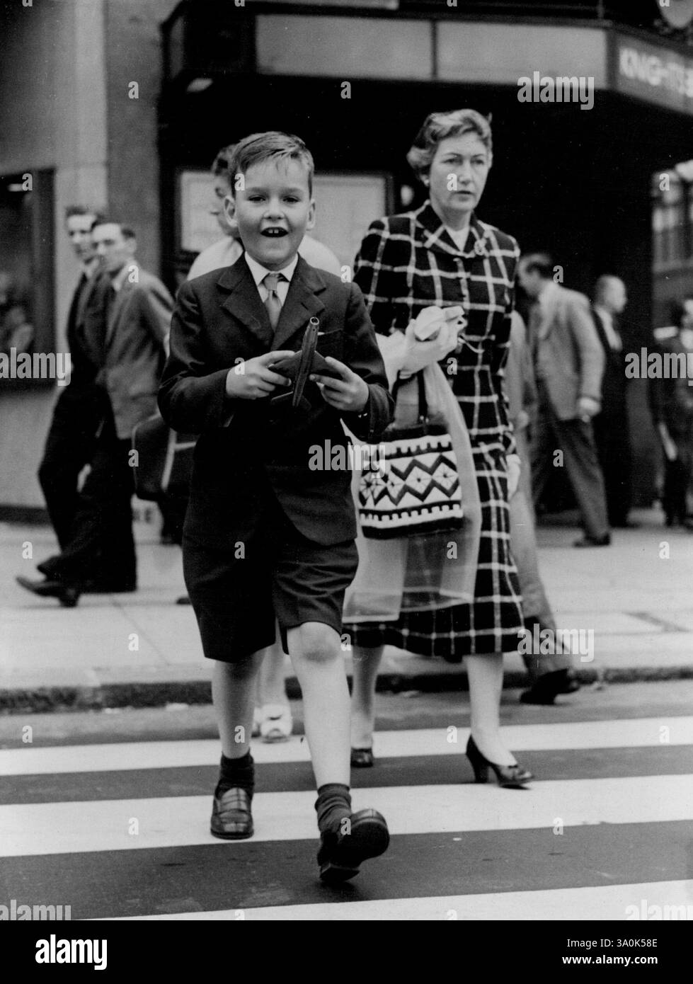 Tommy continua -- Tommy Bata, erede del mondo delle scarpe, di sette anni, soddisfa la tradizione familiare quando è arrivato all'aeroporto di Londra, giorno dopo giorno da New York per iniziare la scuola in Inghilterra. Tommy, la cui casa è in Canada, ha fatto il viaggio da solo da Toronto. Suo padre e sua madre con gli altri due figli sono a New York. La tradizione familiare di autosufficienza è iniziata con il nonno di Tommy, che ha creato la sua attività di produzione di scarpe quando aveva solo 13 anni. Mandò suo figlio Thomas J. Bata, attuale capo dell'azienda internazionale, a scuola in Inghilterra quando aveva sette anni. 22 settembre 1955. Foto Stock