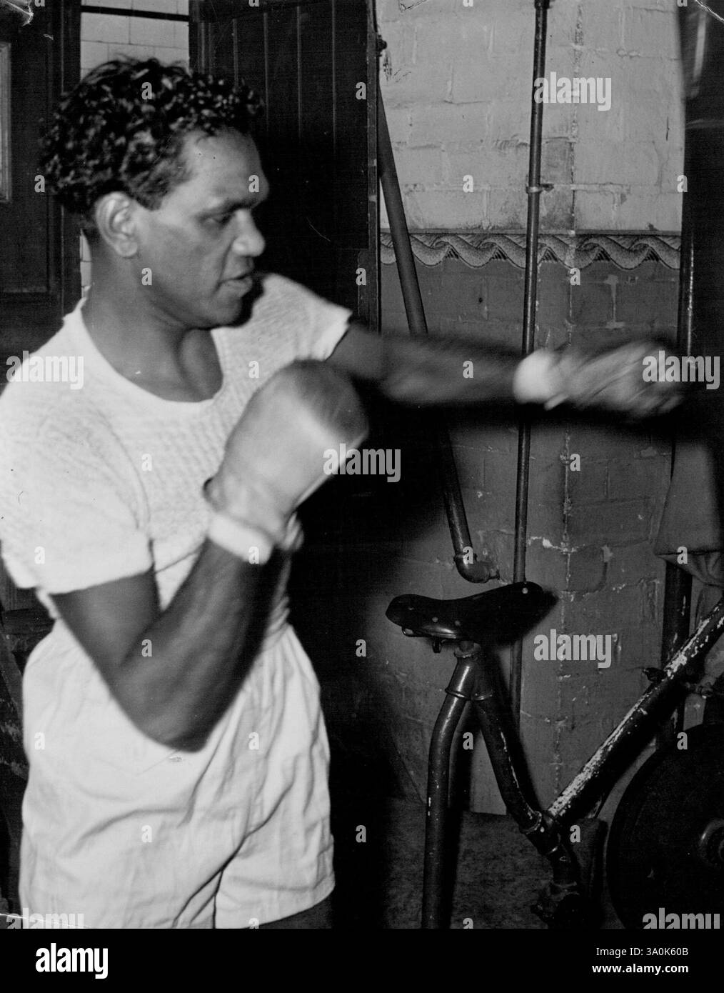 L'australiana Elley Bennett, che incontra l'americano Harold Dade allo stadio lunedì sera, si allena sulla pesante borsa da pugni. 15 ottobre 1949. Foto Stock