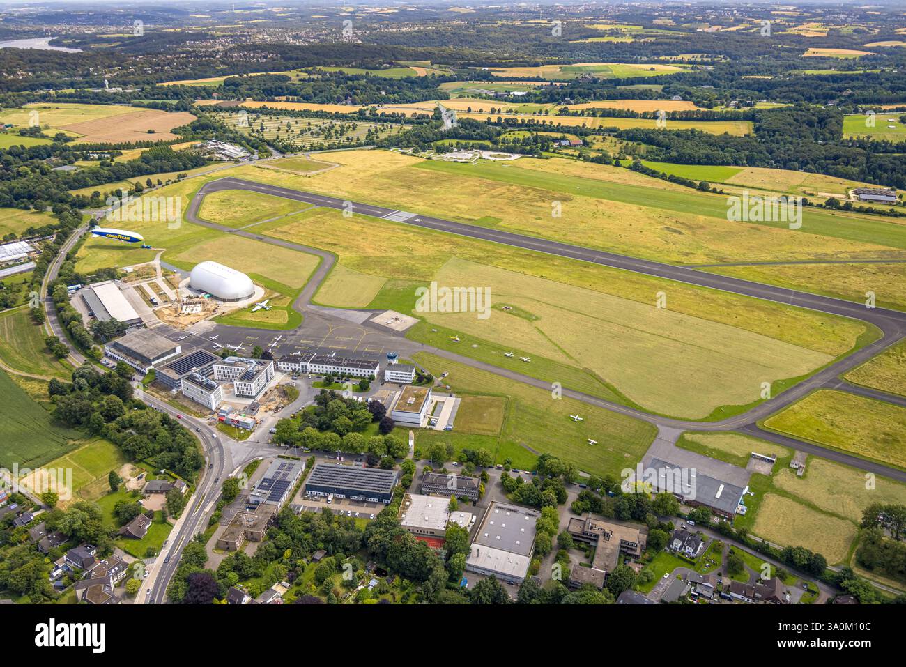 Vista aerea, aeroporto di Essen/Mülheim, pista e pista di atterraggio, cantiere vicino all'hangar del dirigibile e Zeppelin Goodyear, cantiere e cantiere Foto Stock