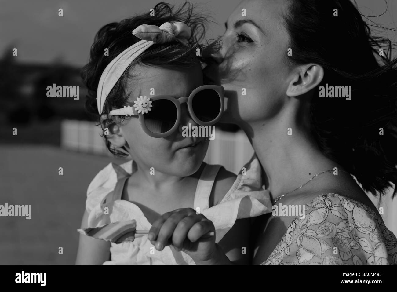 Madre e figlia si godono un gioioso picnic, corrono nel parco, giocano vicino al lago e si divertono in un campo di lavanda. Abiti luminosi, estate Foto Stock