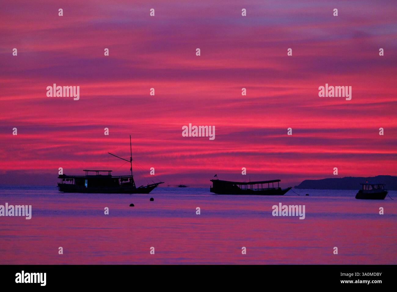 Vista all'alba della barca ormeggiata al largo dell'isola di Seraja Kecil, conosciuta anche come Seraya, al largo della costa di Labuan Bajo, Indonesia. Foto Stock