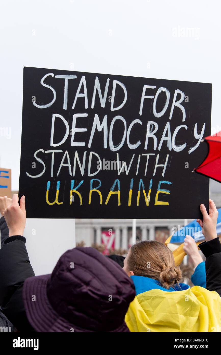 San Francisco, Stati Uniti. 4 marzo 2025. I manifestanti si riuniscono al Civic Center Plaza di fronte al municipio di San Francisco per protestare contro gli ordini esecutivi del presidente Trump e la sua pausa per sostenere l'Ucraina. Un segno di protesta sopra la folla recita: "Difendi la democrazia. State con l'Ucraina. Crediti: Shelly Rivoli/Alamy Live News Foto Stock