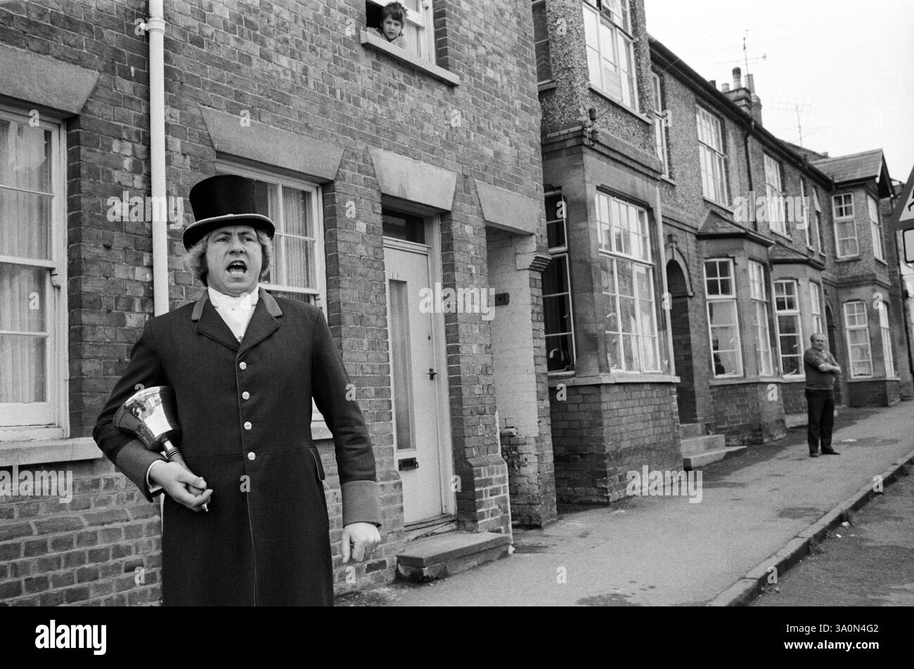 Urlante della città chiama tutti i cittadini comuni al campo Hocktide per le 9 del mattino. Il signor Robin Tubb il Bellman e' uno degli antichi uffici della Citta' e Manor di Hungerford. Il suo ruolo raddoppia come Town Crier, così come Assistant Bailiff, Beadle e Crier per le corti di Hocktide. I membri della famiglia di Tubb sono stati campanili a Hungerford per oltre 300 anni. Il festival Hocktide si svolge il secondo martedì dopo Pasqua. Hungerford, West Berkshire Inghilterra anni 1976 1970 UK HOMER SYKES Foto Stock