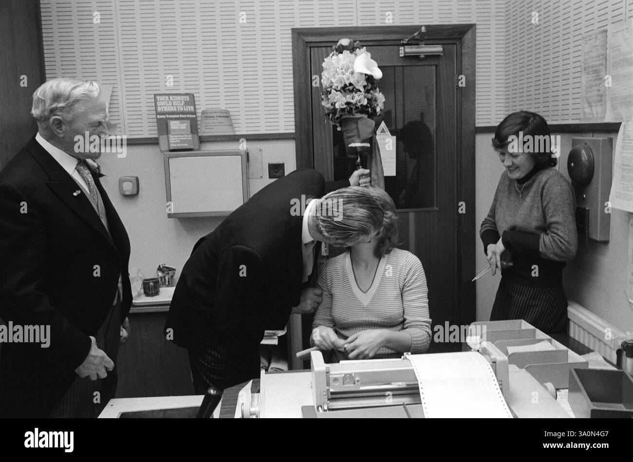 Hungerford Hocktide, tutti uomini con personale di ufficio, un palo con fiori alla testa passeggia per la città e dentro e fuori dal vecchio edificio tradizionale. I Tuttimen baciano qualsiasi donna in cambio di un'arancia. Questo è un simbolo di fortuna e prosperità per il prossimo anno, l'Orangeman (non nella foto) porta un sacco di arance sulla sua spalla. Hungerford, West Berkshire, Inghilterra 1976 1970s UK HOMER SYKES Foto Stock
