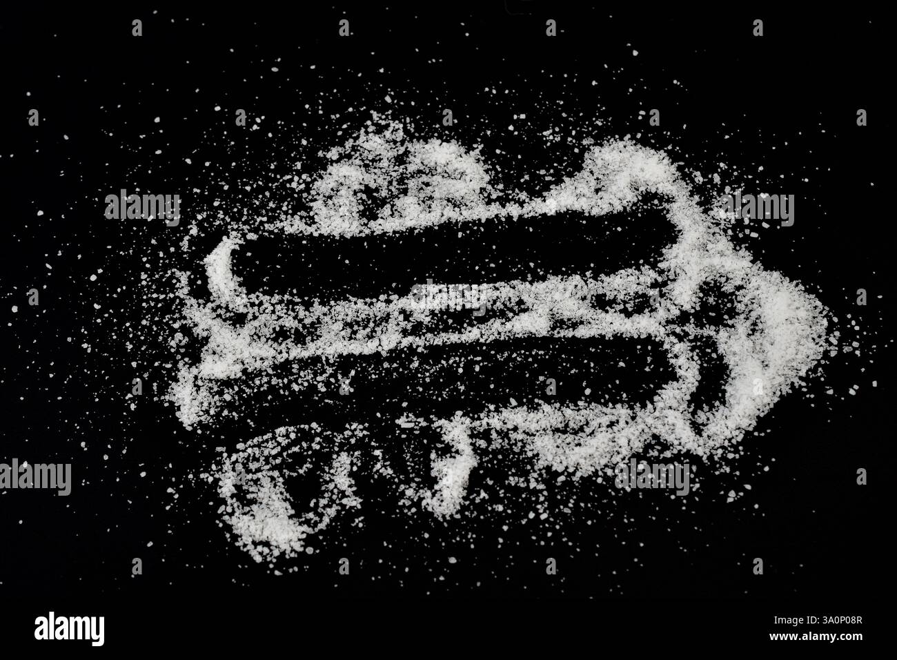Cristalli bianchi di sale da tavola sono sparsi su uno sfondo nero. Foto Stock