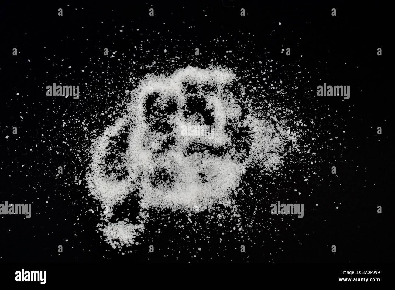 Cristalli bianchi di sale da tavola sono sparsi su uno sfondo nero. Foto Stock