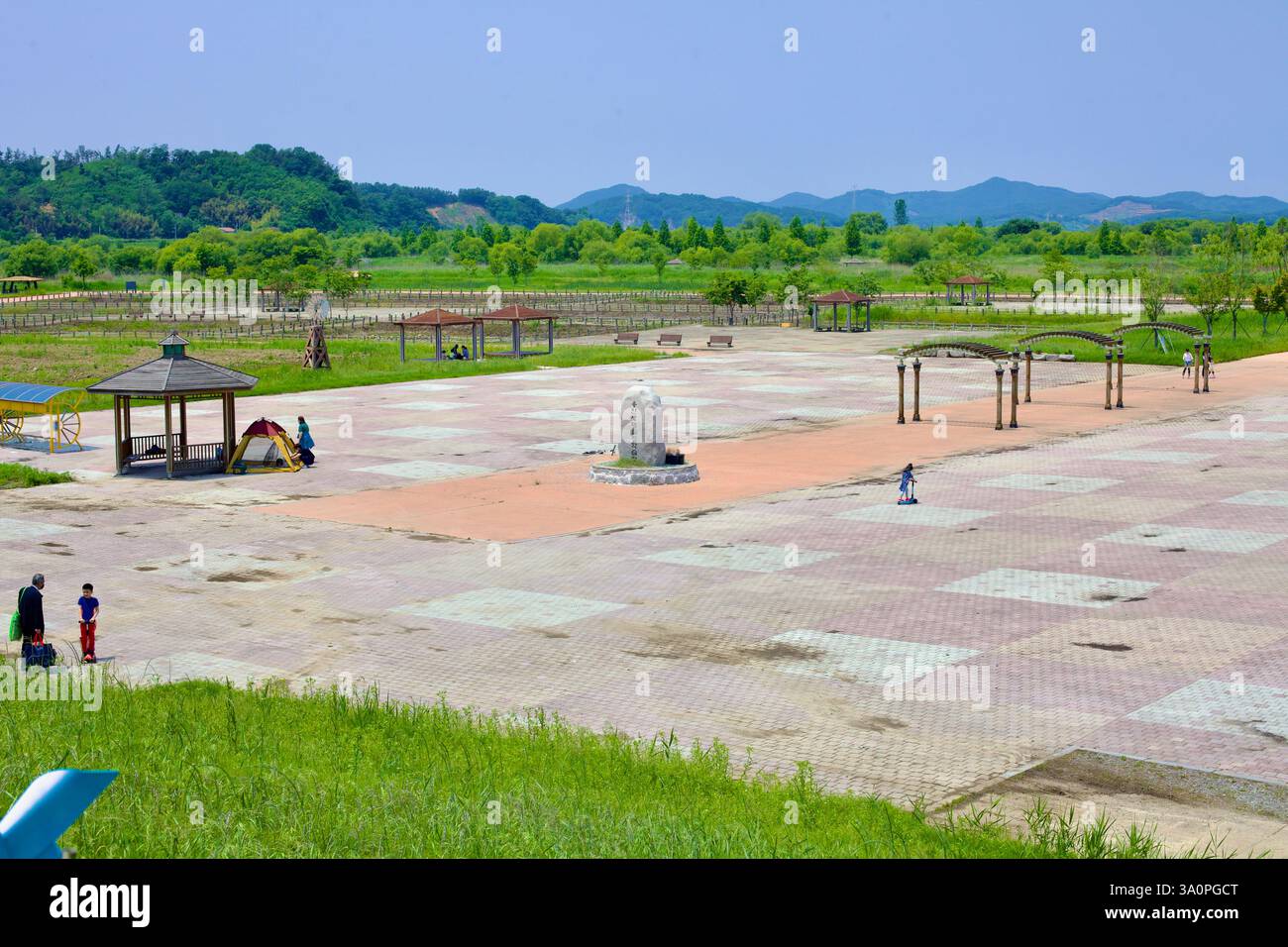 Iksan, Corea del Sud - 27 maggio 2021: Le famiglie si riuniscono nella spaziosa piazza del parco ecologico delle paludi di Yongan, con gazebo, sentieri per passeggiate e un centro benessere Foto Stock