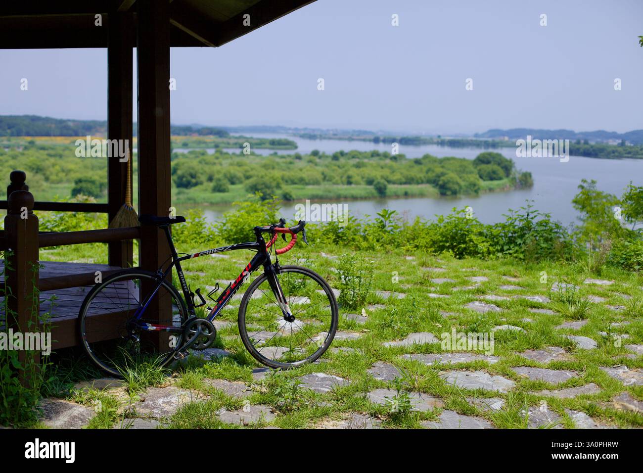 Città di Iksan, Corea del Sud - 27 maggio 2021: Una bici da strada si appoggia su un gazebo in legno che si affaccia sul fiume Geum, offrendo ai ciclisti una sosta ombreggiata Foto Stock