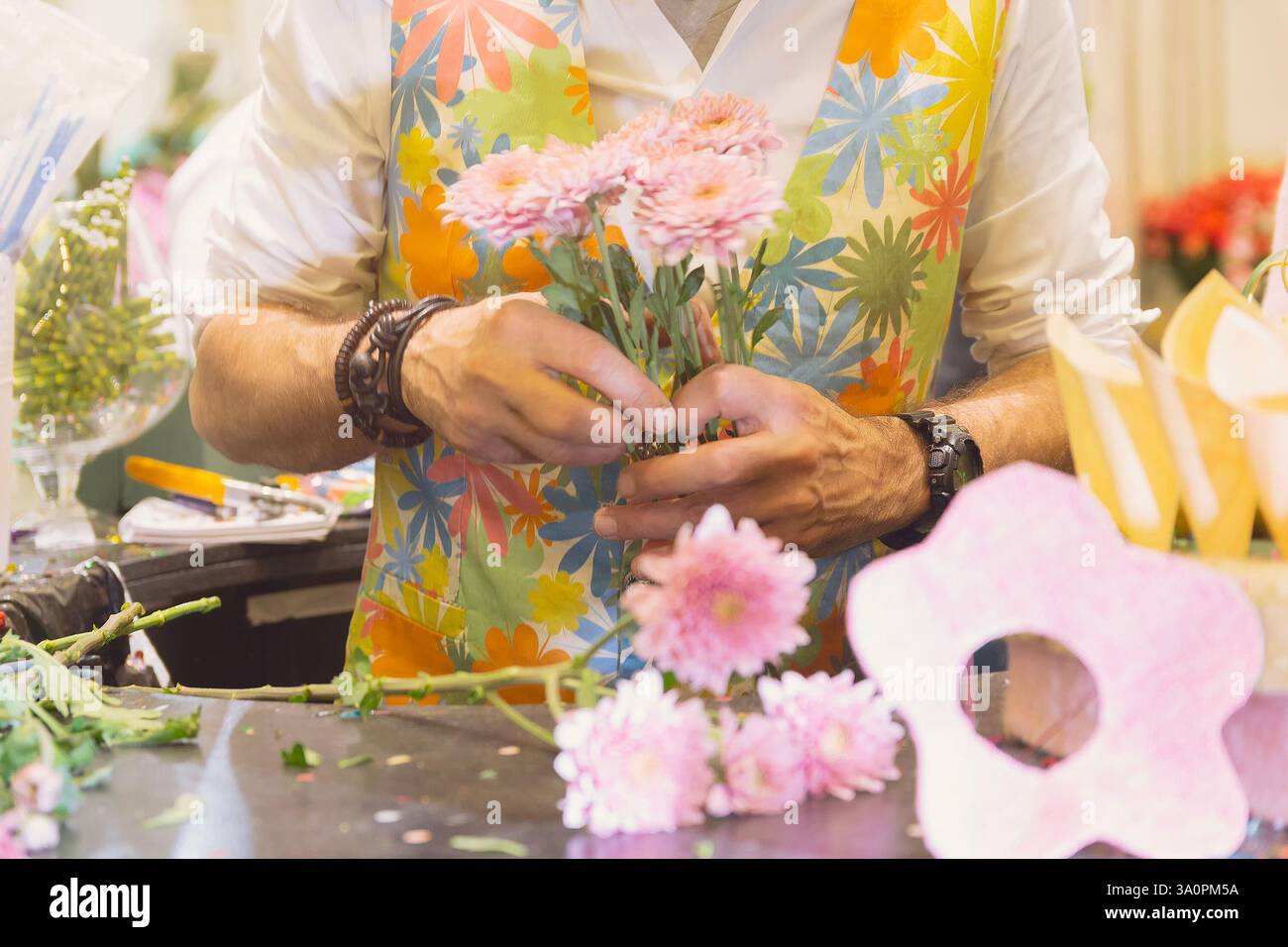 Fioraio uomo che colleziona bouquet in un negozio di fiori Foto Stock