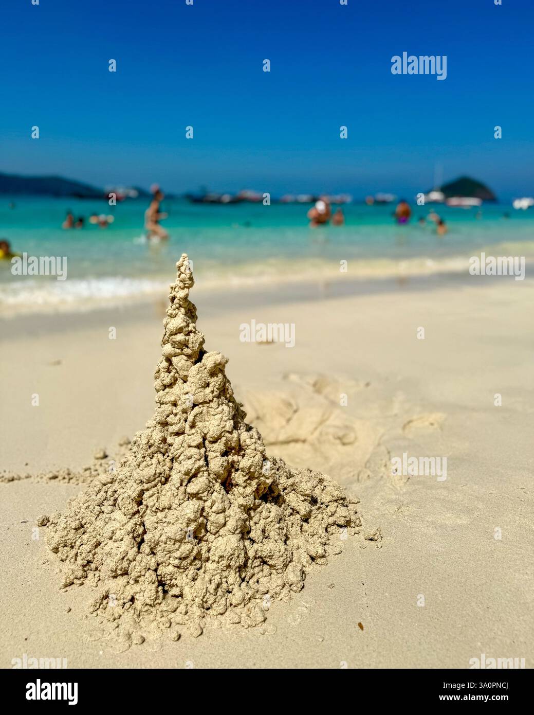 Castello di sabbia artistico su una Sunny Beach 2 Un castello di sabbia scolpito naturalmente sorge dalla spiaggia baciata dal sole, mostrando la sua struttura intricata e organica. - Immagine stock catturata con smartphone