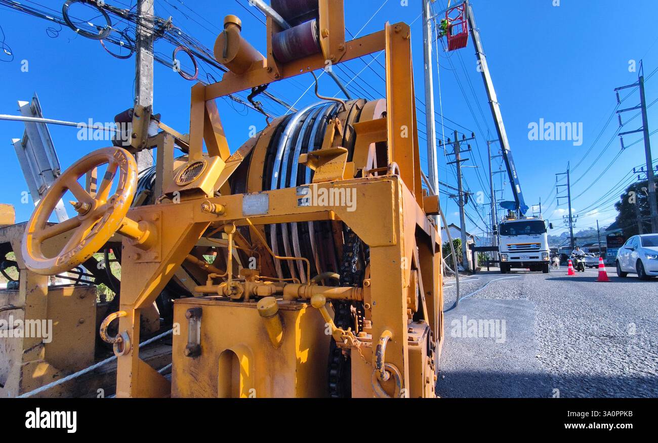 Installazione di fili elettrici ad alta tensione su nuovi poli lungo la strada. Foto Stock