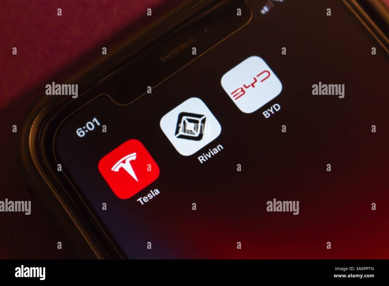 Le icone Tesla, Rivian e BYD vengono visualizzate su un iPhone. Leader nella produzione di veicoli elettrici, guida l'innovazione e la transizione globale al concetto di mobilità elettrica. Foto Stock