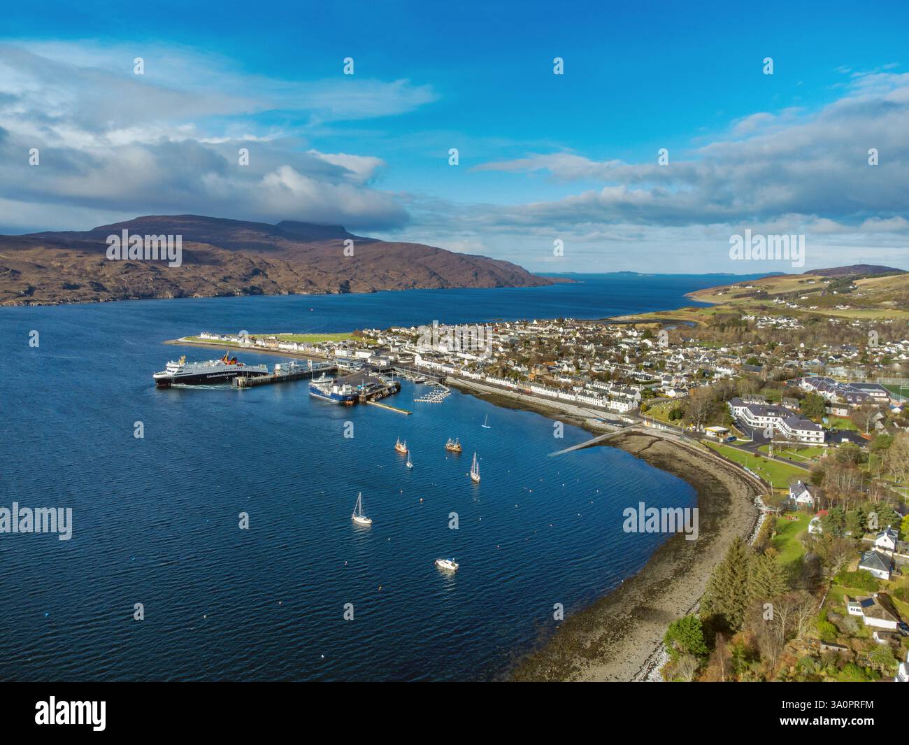 Porto e villaggio di Ullapool in Scozia e Loch Broom visto dall'alto. Un traghetto Caledonian MacBrayne può essere visto lasciare il porto Foto Stock