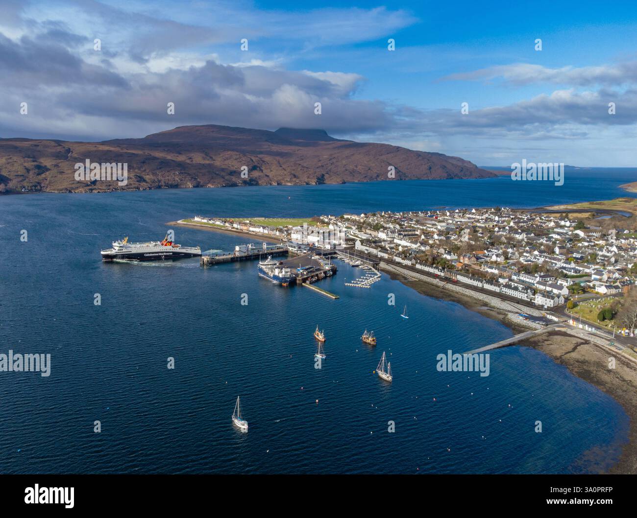 Porto e villaggio di Ullapool in Scozia e Loch Broom visto dall'alto. Un traghetto Caledonian MacBrayne può essere visto lasciare il porto Foto Stock