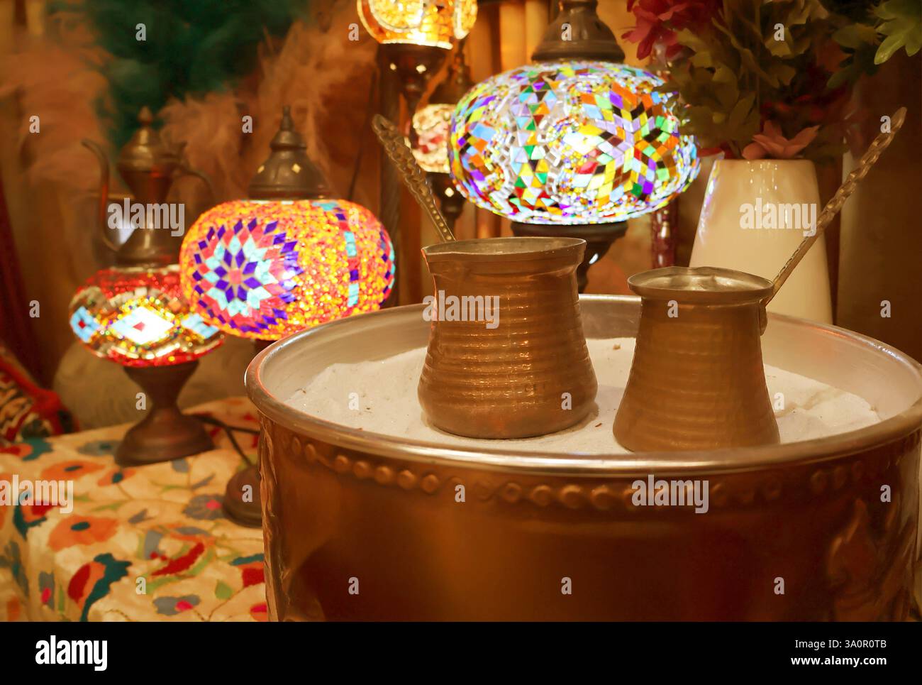 Primo piano di caldaie per caffè turche chiamate Cezve poste sulla sabbia calda Foto Stock