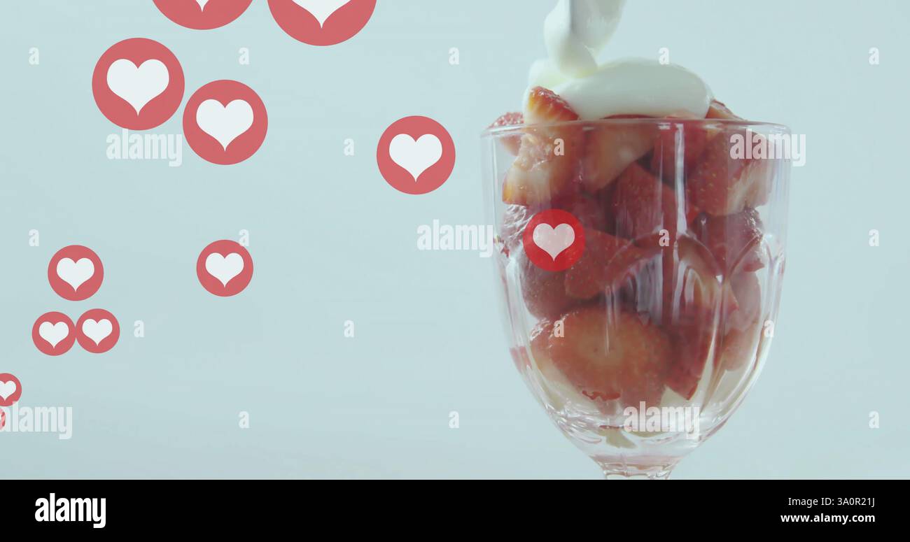 Versare la panna sulle fragole in vetro con l'immagine delle icone del cuore Foto Stock