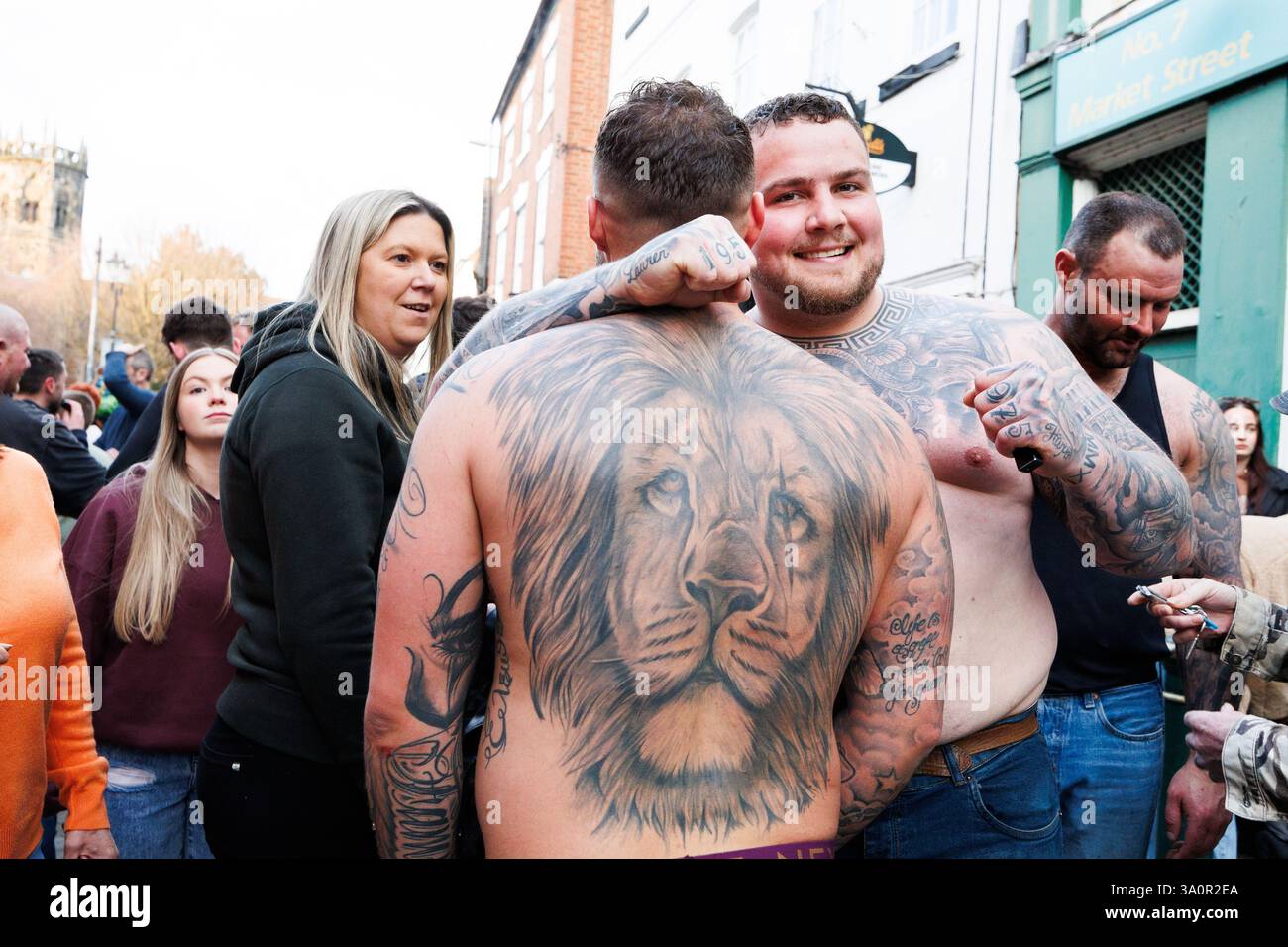 Atherstone Ball Game 2025. Nella foto, i concorrenti al di fuori del Club Liberale nella Piazza del mercato dopo la fine del gioco di palla. L'Atherstone Ball Game è una partita di "calcio medievale" giocata ogni anno lo Shrove Tuesday nella città inglese di Atherstone, Warwickshire. La partita onora una partita giocata tra Leicestershire e Warwickshire nel 1199, quando le squadre gareggiarono per una borsa d'oro, e che fu vinta dal Warwickshire. Un tempo eventi simili si tennero in molte città in tutta l'Inghilterra, ma quello di Atherstone è ora uno di almeno tre di questi giochi che vengono ancora giocati ogni anno a Shrovetide. Foto Stock