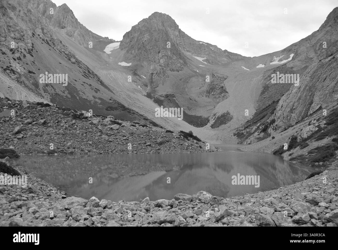 Foto in bianco e nero di un lago in cima alla montagna nelle Green Highlands in una giornata soleggiata e nuvolosa Foto Stock
