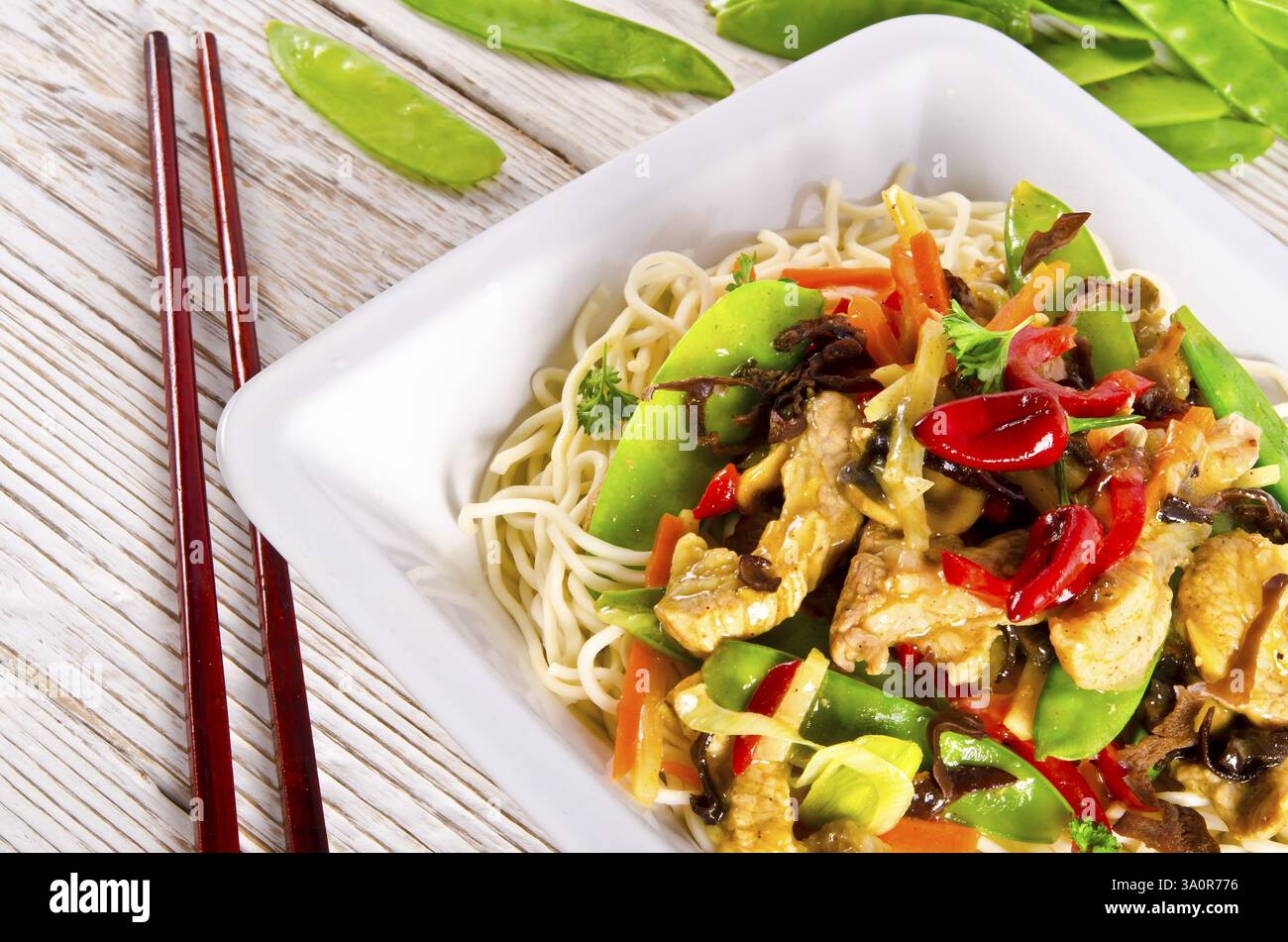 Tagliatelle con carne di maiale e verdure in salsa di prugne Foto Stock