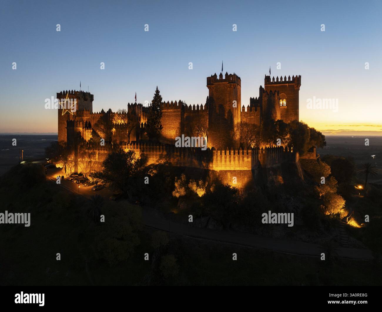 L'imponente castello moresco di Almodovar del Rio, risalente all'VIII secolo, si erge sopra la valle del fiume Guadalquivir. Illuminato al crepuscolo. Colpo di drone. Cai¿½ Foto Stock