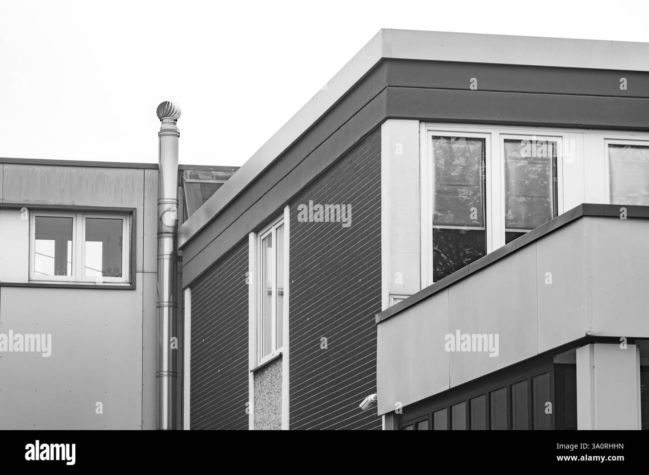 Edificio moderno che presenta forme geometriche, linee e trame, catturate in monocromia Foto Stock