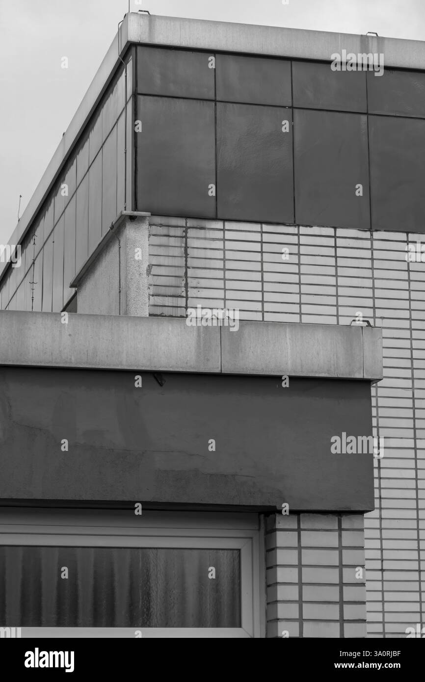 Facciata moderna che mostra forme geometriche, texture e vari materiali da costruzione in monocromia Foto Stock