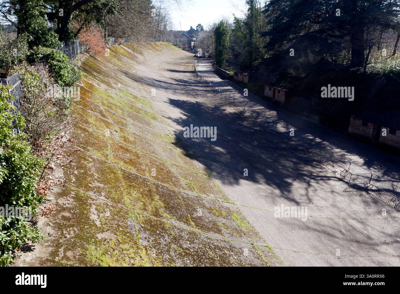 Vista su una sezione banchinata del circuito di Brooklands in cemento, è stato il primo circuito automobilistico costruito appositamente al mondo. Foto Stock