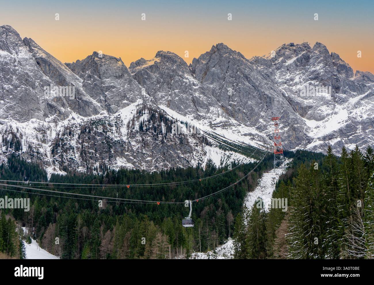 Funivia di Zugspitz presso lo Zugspitze nelle Alpi tedesche in inverno con neve e cielo blu al tramonto Foto Stock