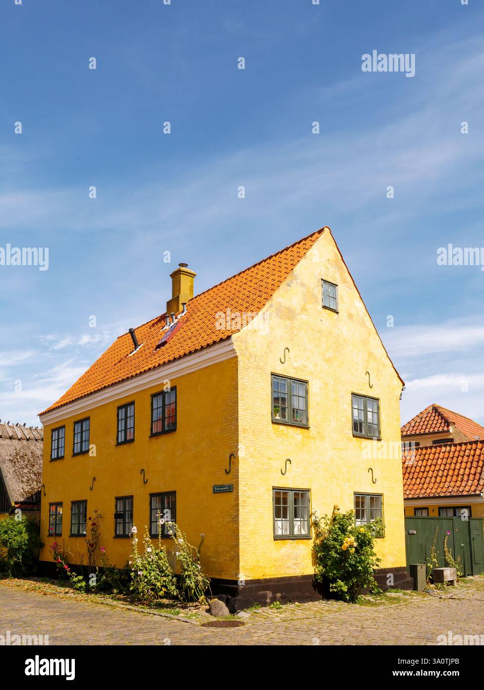 Storica villa gialla a due piani con tetto in piastrelle rosse a Strandgade nella città vecchia di Dragør, isola di Amager, regione della capitale, Danimarca Foto Stock