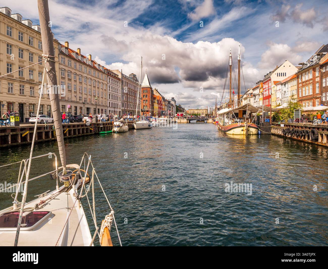 Navigazione sul prato della barca a vela nel canale Nyhavn, mostrando le storiche case cittadine su entrambi i banchine nel centro di Copenaghen, Danimarca Foto Stock