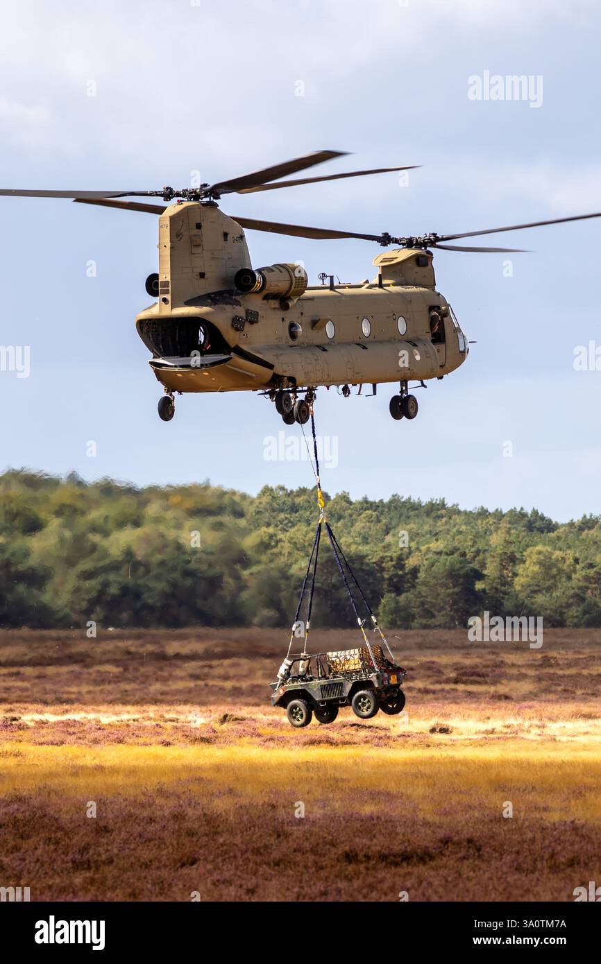 Trasporto militare di veicoli fuoristrada con un elicottero Boeing CH-47F Chinook. Ginkelse Heide, Paesi Bassi - 17 settembre 2022 Foto Stock