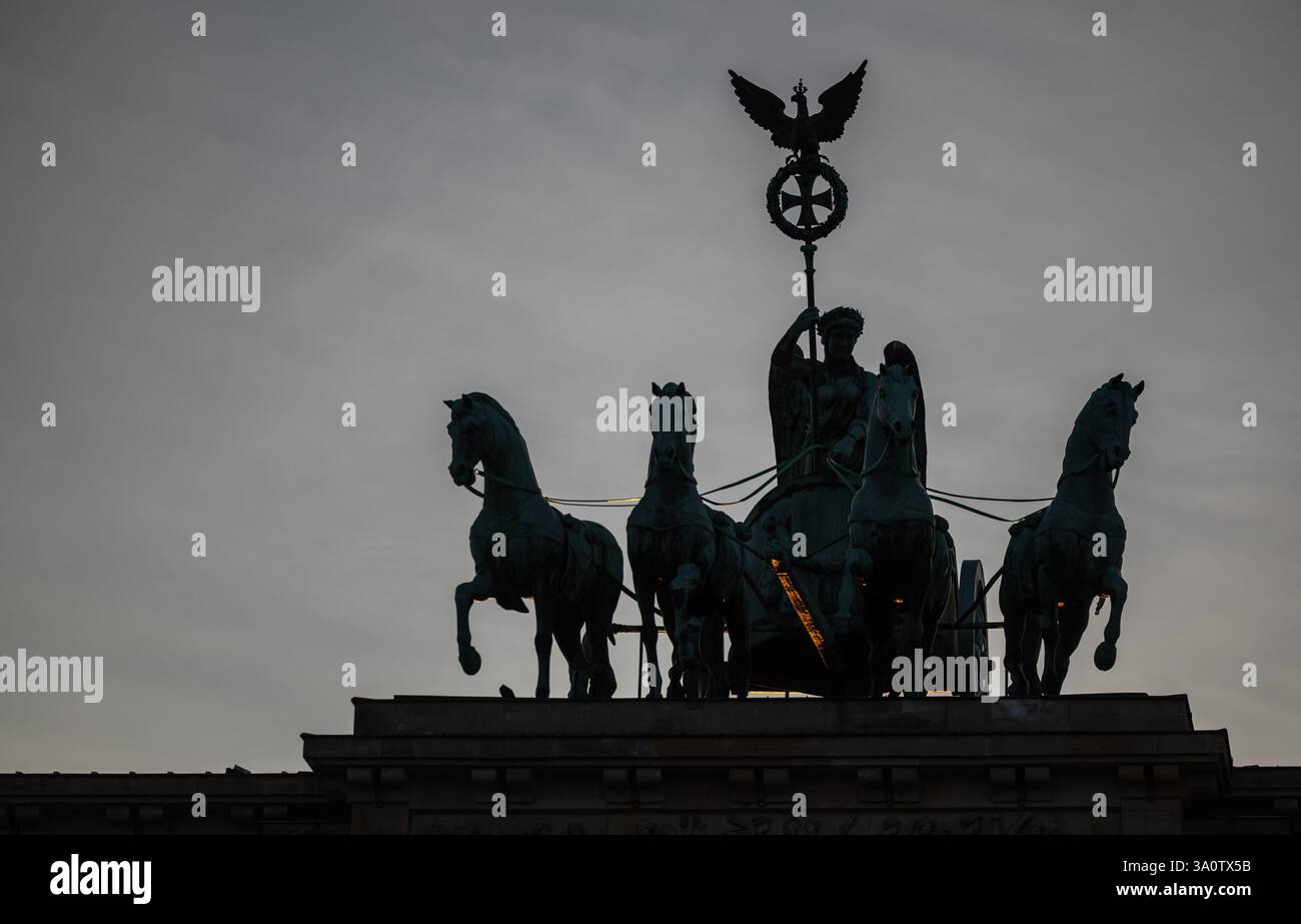Berlino, Germania. 4 marzo 2025. I raggi del sole illuminano parte della Quadriga sulla porta di Brandeburgo al tramonto. Crediti: Hannes P. Albert/dpa/Alamy Live News Foto Stock
