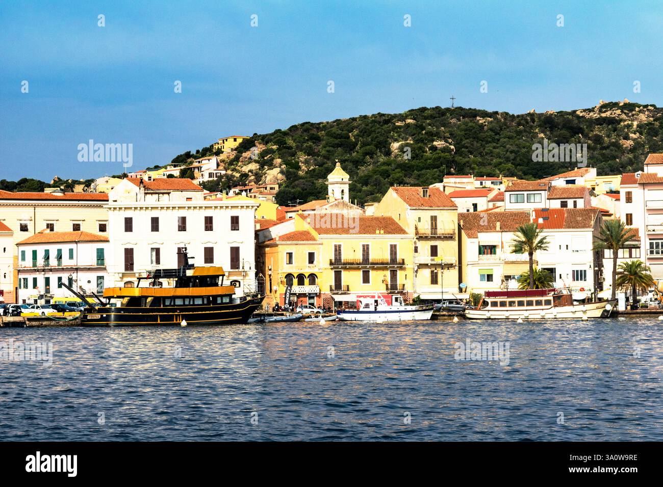 Colorati edifici sul molo nel porto di la Madellena con piacere ormeggiato e gita di un giorno in barca, Sardegna, Italia. Foto Stock