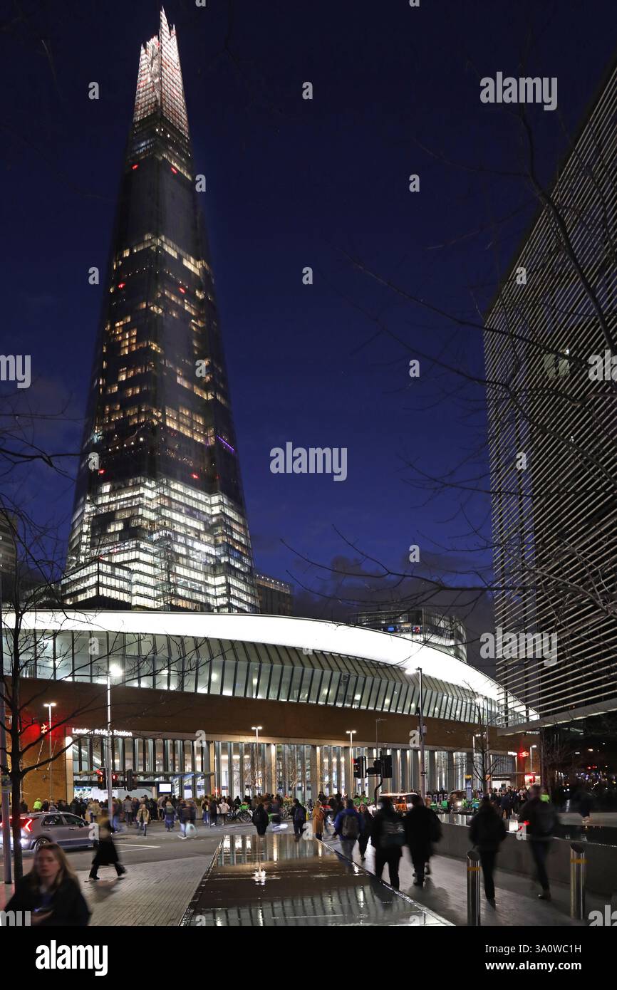Strada trafficata fuori dalla stazione di London Bridge (ingresso nord) al crepuscolo. Mostra The Shard, l'edificio più alto del Regno Unito. Foto Stock
