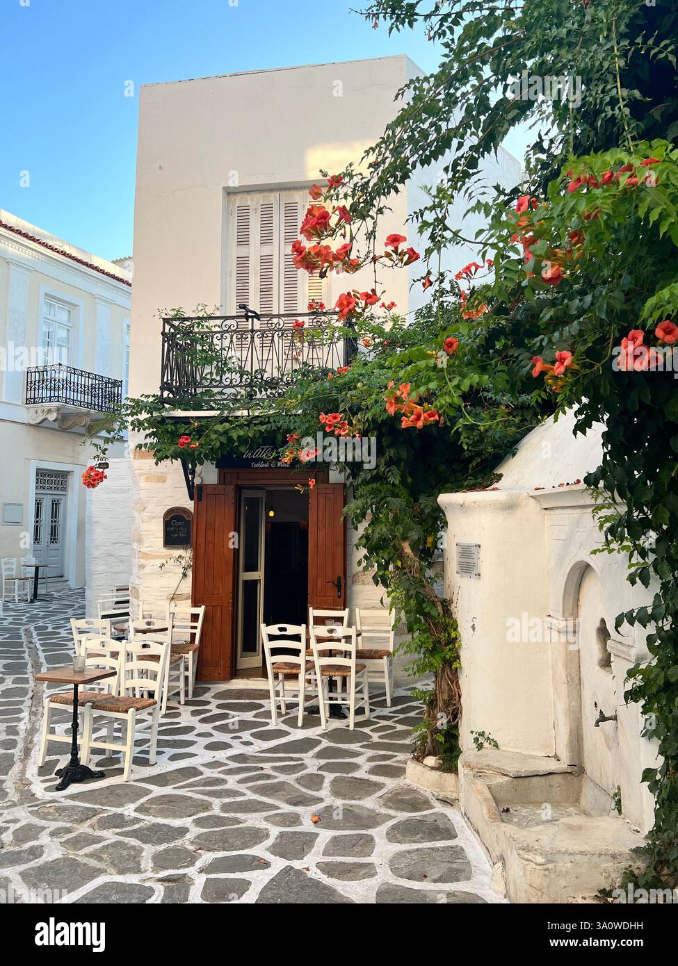 Accogliente caffetteria all'aperto con fiori in fiore in un pittoresco villaggio mediterraneo Foto Stock