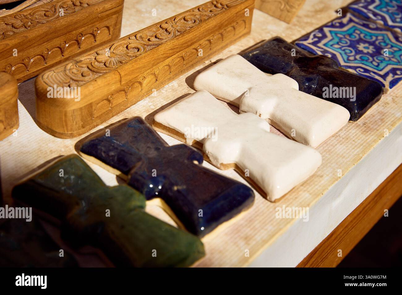 Mosaico a forma di croce, piastrelle in ceramica smaltate dipinte a mano, souvenir al mercato di strada di Khiva, Uzbekistan Foto Stock