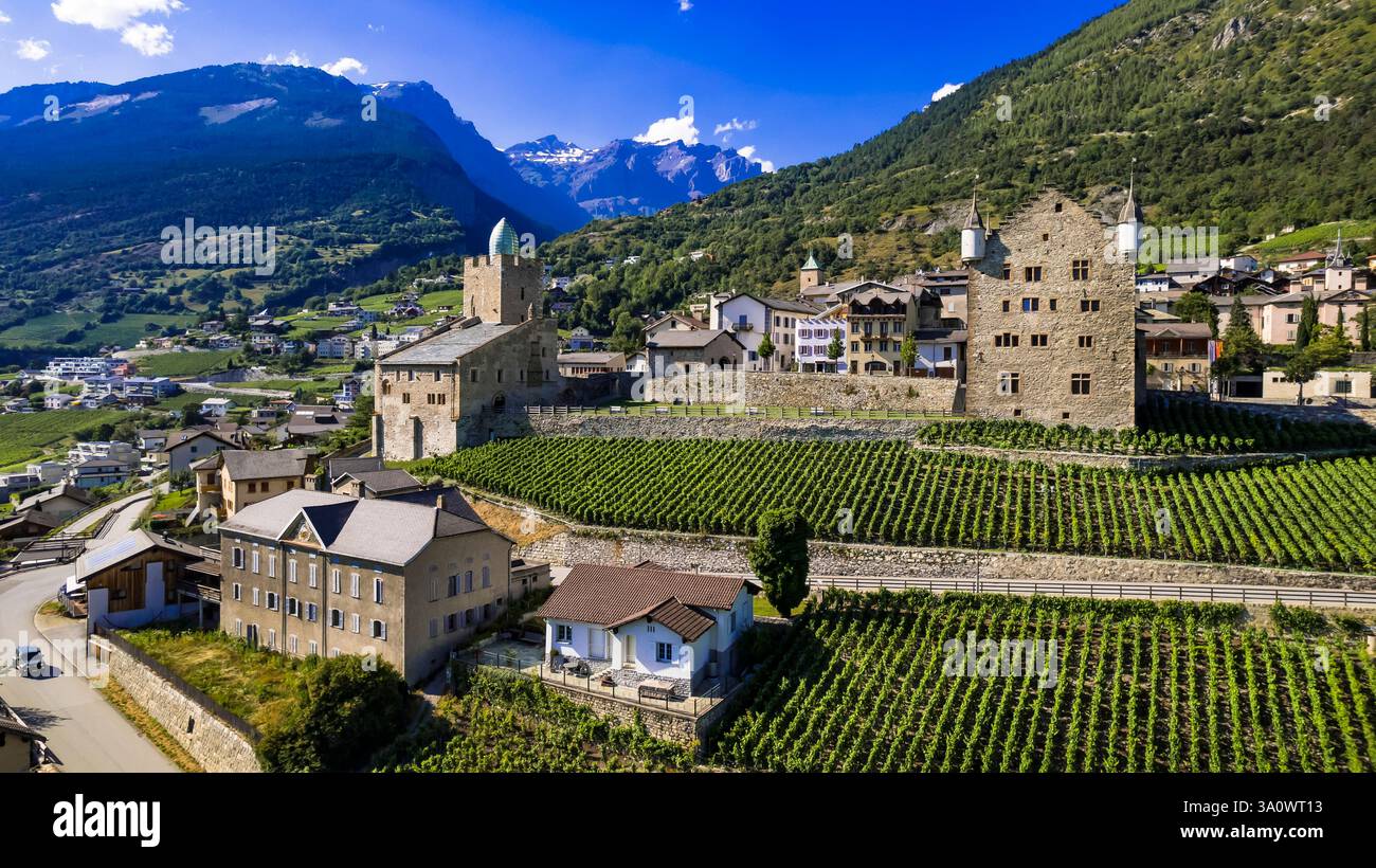 Viaggi in Svizzera, luoghi panoramici nel Canton Vallese. Città di Leuk circondata da vigneti e montagne alpine. Panorama aereo con droni e castelli medievali Foto Stock