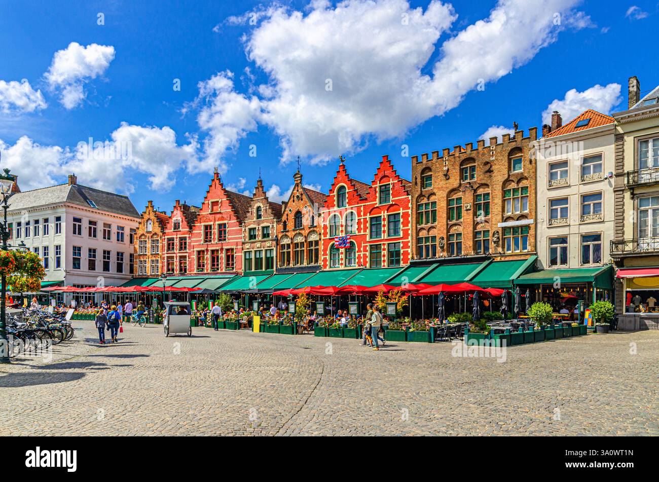 Edifici tradizionali fiamminghi in stile barocco con facciate colorate e ristoranti sulla piazza del mercato nella città vecchia di Bruges Foto Stock