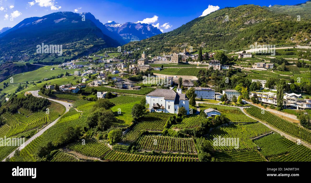 Viaggi in Svizzera, luoghi panoramici nel Canton Vallese. Città di Leuk circondata da vigneti e montagne. Panorama aereo con droni con castelli medievali e Foto Stock