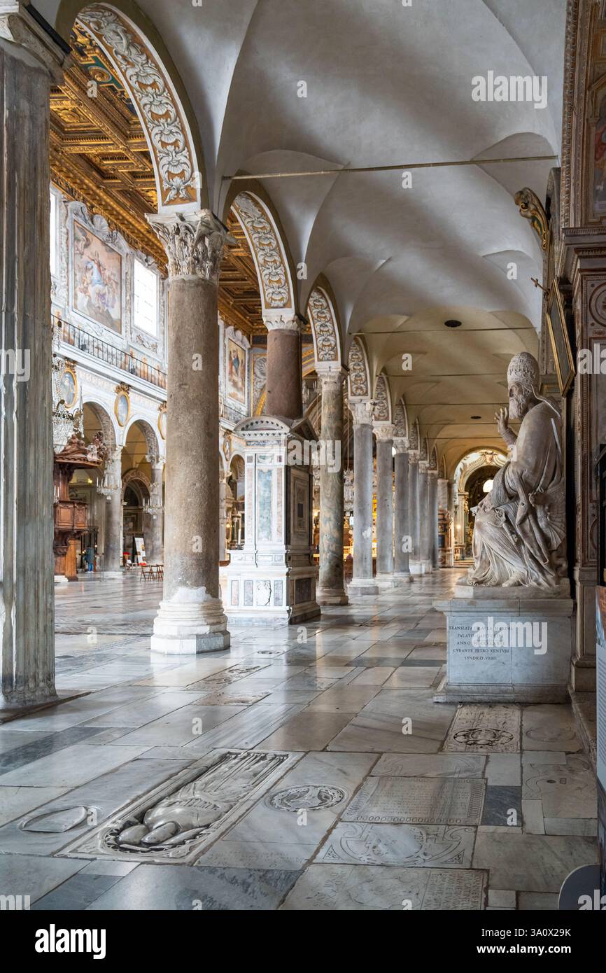 Vista laterale della statua in marmo del papa che decora una sala all'interno della chiesa storica di Roma Foto Stock