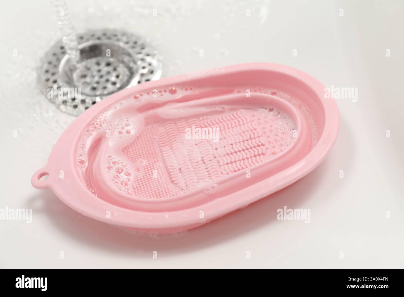 Tampone in silicone per la pulizia delle spazzole per il trucco nel lavello, primo piano Foto Stock