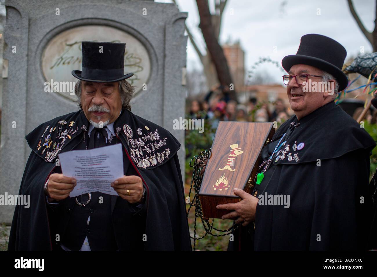 Madrid, Spagna. 5 marzo 2025. Un membro della fratellanza legge un discorso mentre un altro tiene la bara con la sardina all'interno, durante la celebrazione della sepoltura della parata sardina che ha girato le strade di Madrid . La sepoltura della festa sarda è una processione funebre che si celebra ogni mercoledì delle ceneri, per salutare la settimana carnevalesca, risalente al XVIII secolo e che segna i quaranta giorni prima dell'arrivo della settimana Santa. Credito: SOPA Images Limited/Alamy Live News Foto Stock