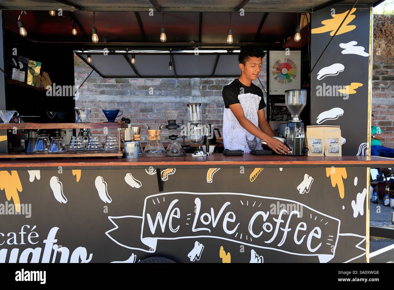 Un giovane barista maschio che lavora in una caffetteria mobile per le strade della città storica di Juayua. El Salvador Foto Stock