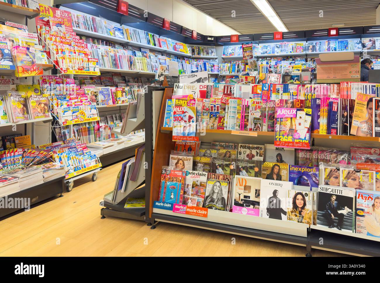 Parigi, Francia - 28 dicembre 2024: Un'ampia gamma di riviste colorate si staglia sugli scaffali in una libreria ben fornita, che offre una vasta selezione di argomenti Foto Stock