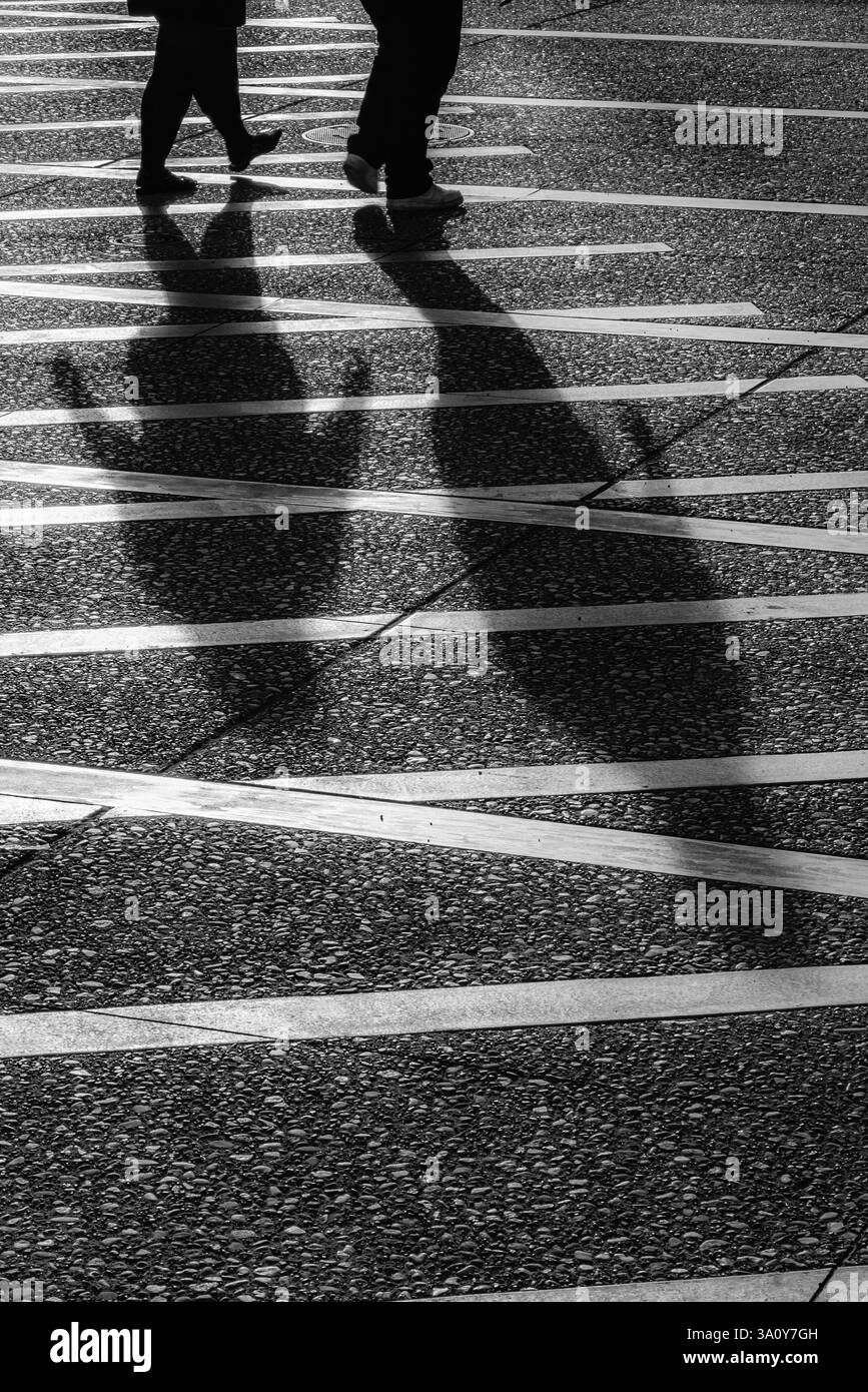 Ombre di persone che attraversano Alaska Way a Seattle, Washington State, Stati Uniti Foto Stock
