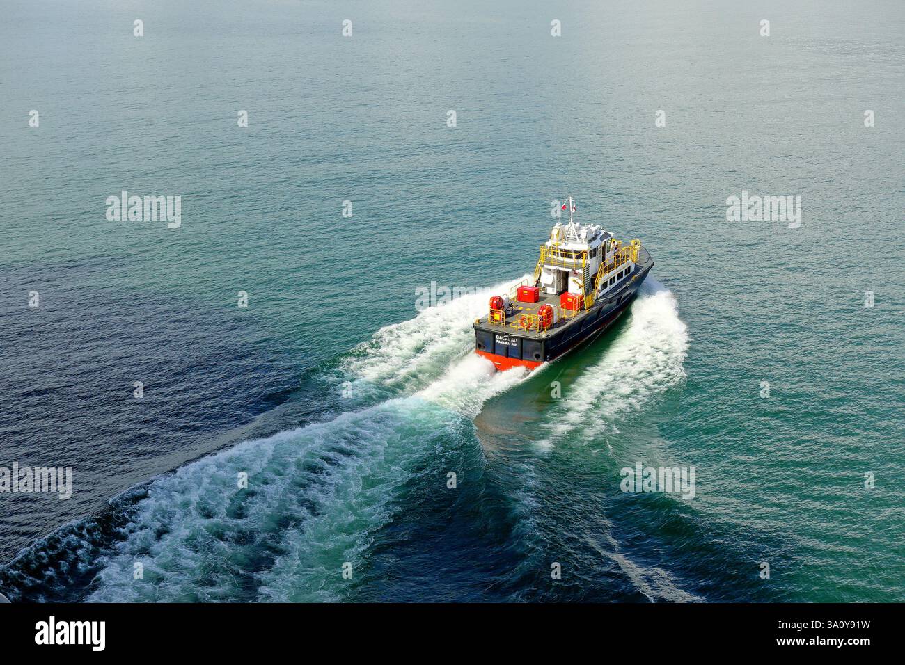 Vista della barca pilota del Canale di Panama che crea violente surf bianco sulla cima dell'acqua verde del Lago Gatun Foto Stock