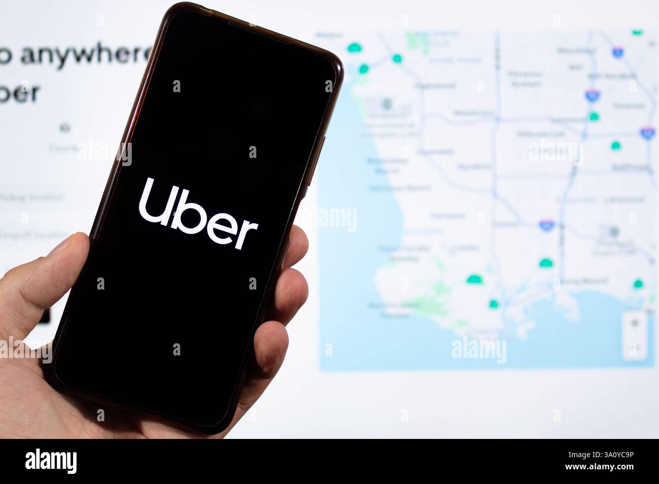 BOGOTÀ, COLOMBIA - 05 MARZO 2025 uno smartphone con logo Uber app e sfocata interfaccia social media sullo sfondo Foto Stock
