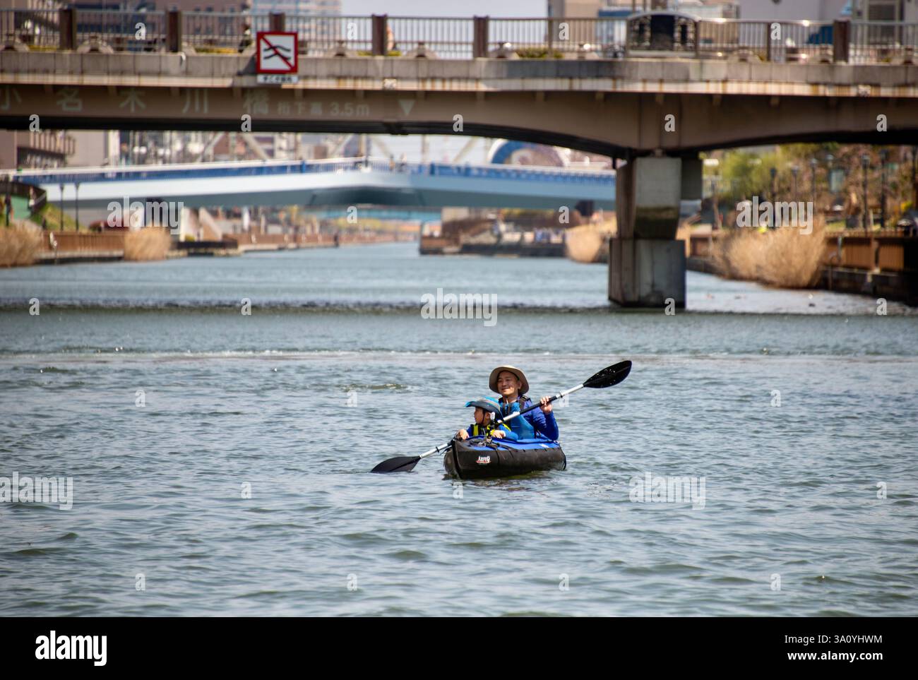 Una donna e un bambino pagaiano sul fiume Sumida a Chuo Ward Tokyo, Giappone, il 5 aprile 2017. FOTO ROB GILHOOLY Foto Stock