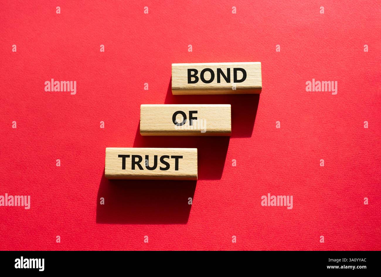 Simbolo del legame di fiducia. Blocchi di legno con parole Bond of Trust. Bellissimo sfondo rosso. Business e Bond of Trust. Copia spazio. Foto Stock