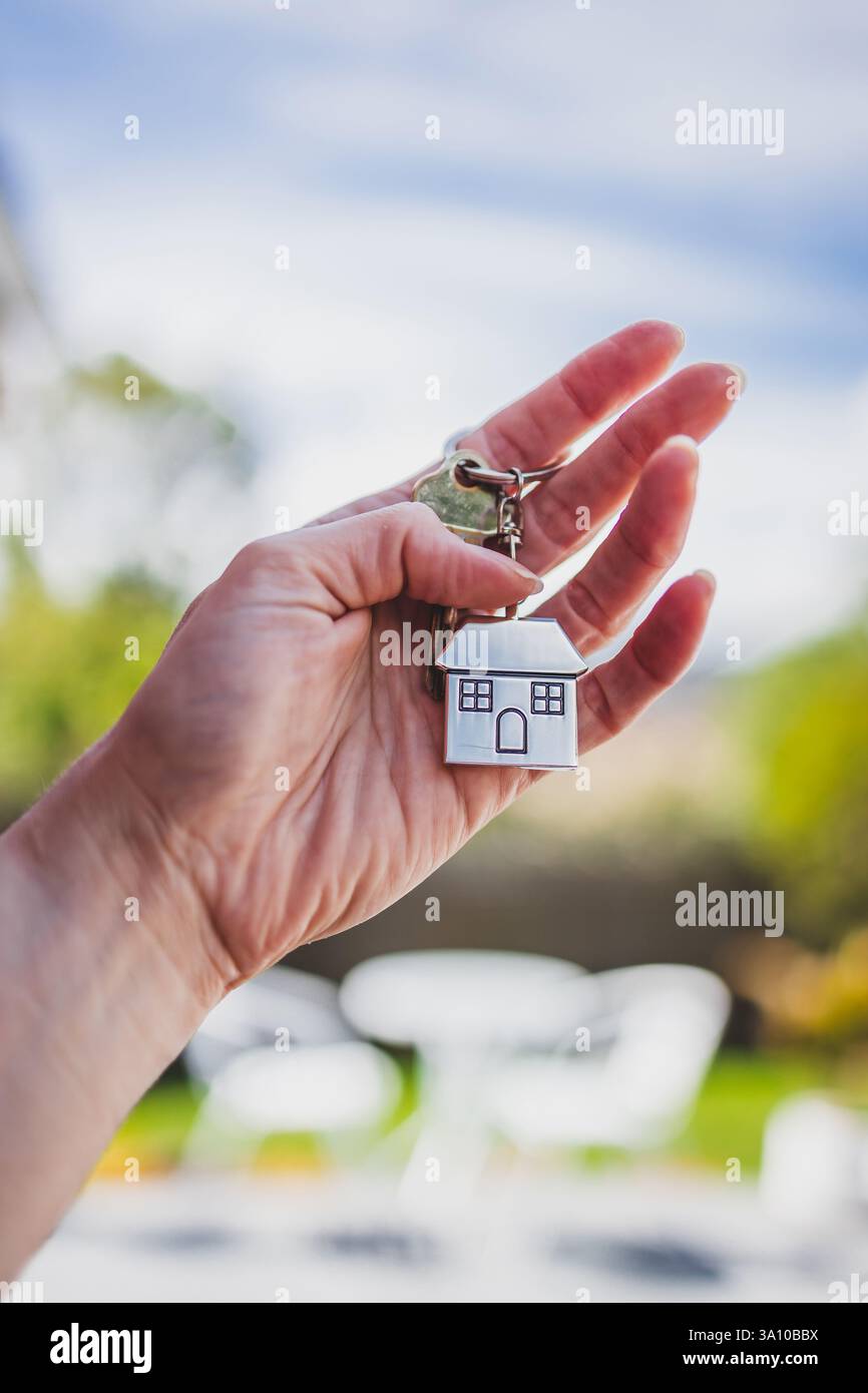portachiavi a forma di casa con la chiave davanti al patio sul retro bokeh, alla casa dei sogni e al concetto di proprietà della casa (la chiave è una vecchia chiave che non lo fa Foto Stock portachiavi a forma di casa con la chiave davanti al patio sul retro bokeh, alla casa dei sogni e al concetto di proprietà della casa (la chiave è una vecchia chiave che non lo fa Foto Stock